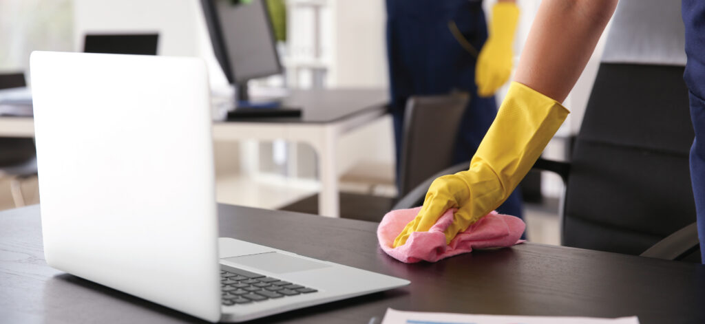 cleaning worker wiping off an office desk