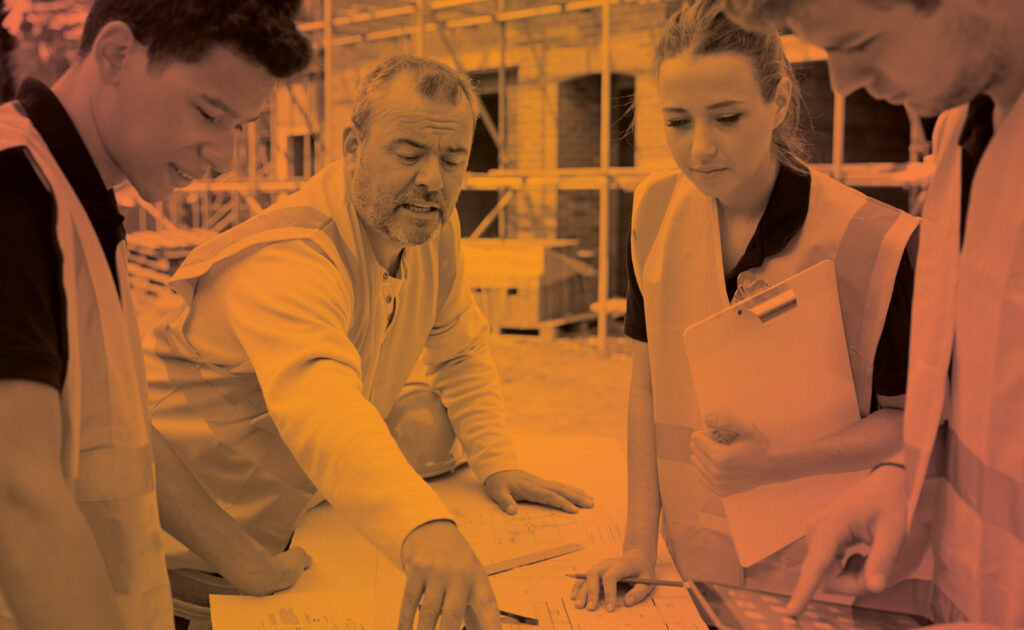 Photo of a construction leader explaining blueprints to three Gen Z youths