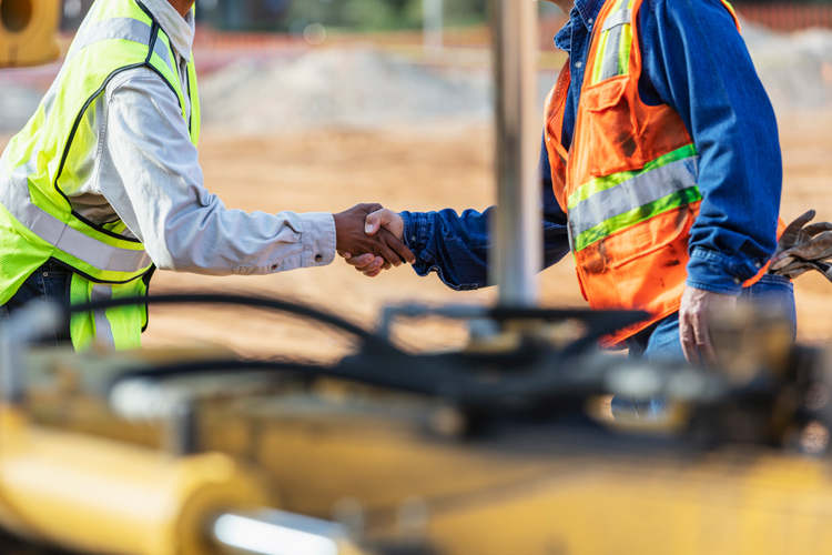 Image of two construction workers shaking hands