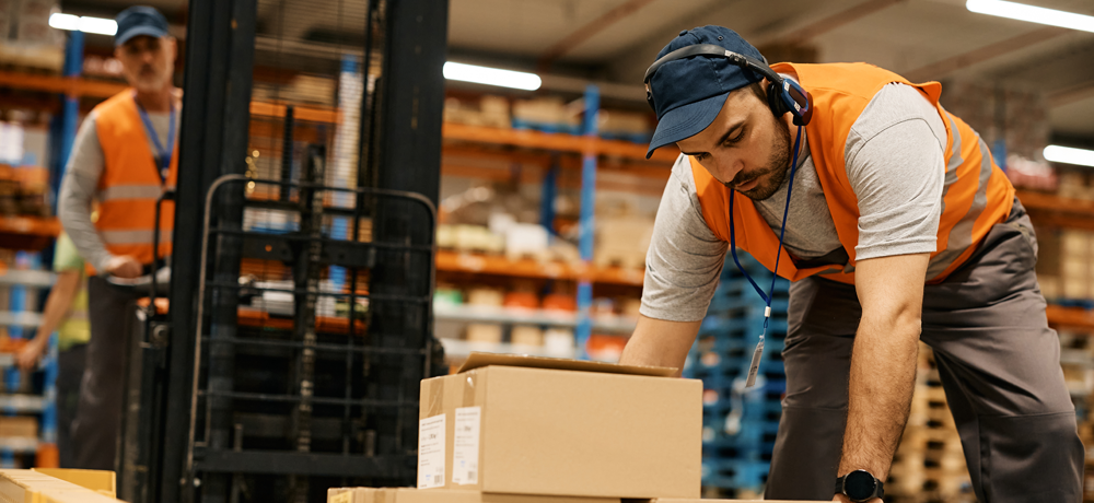 Warehouse and distribution workers moving boxes in a warehouse facility.